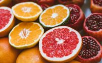 Vibrant close-up of sliced citrus fruits and pomegranates showcasing freshness and variety.
